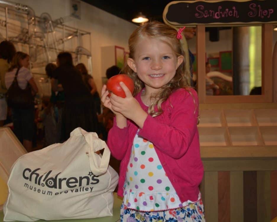 Girl with apple at Children's Museum Oro Valley